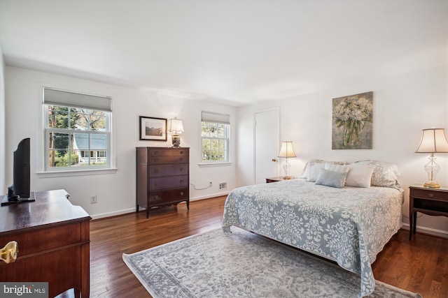 bedroom with dark wood-style floors and baseboards