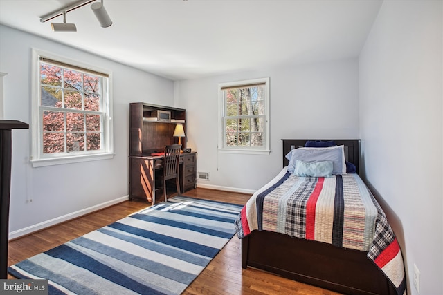 bedroom featuring wood finished floors, baseboards, and visible vents