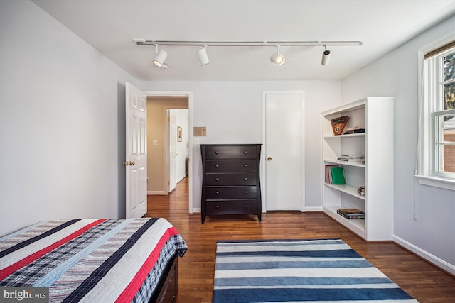 bedroom with wood finished floors and baseboards