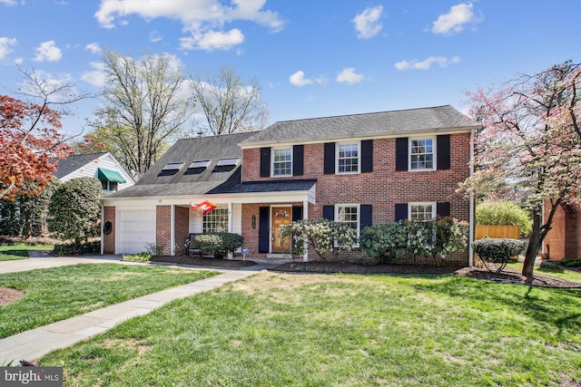 view of front of house with brick siding, driveway, a garage, and a front yard