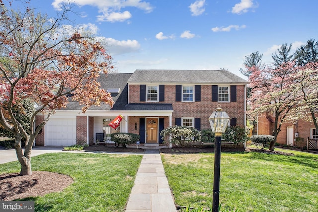 view of front of house featuring covered porch, a front yard, brick siding, a garage, and concrete driveway