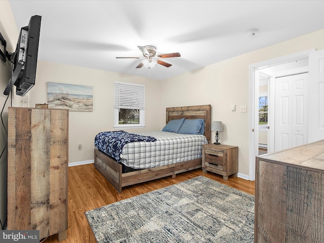 bedroom featuring wood finished floors, baseboards, and a ceiling fan