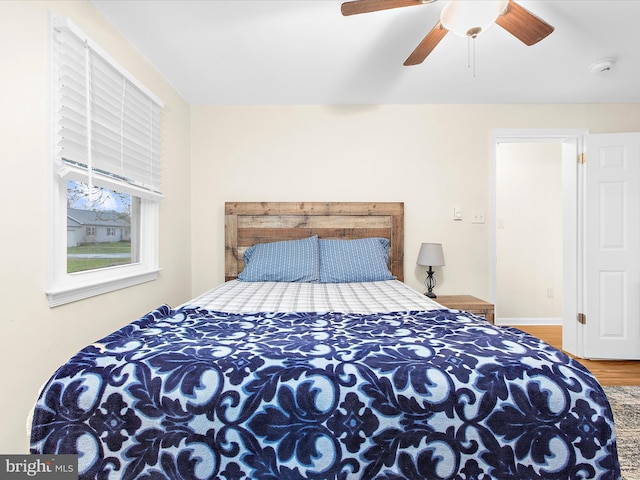 bedroom featuring ceiling fan, wood finished floors, and baseboards