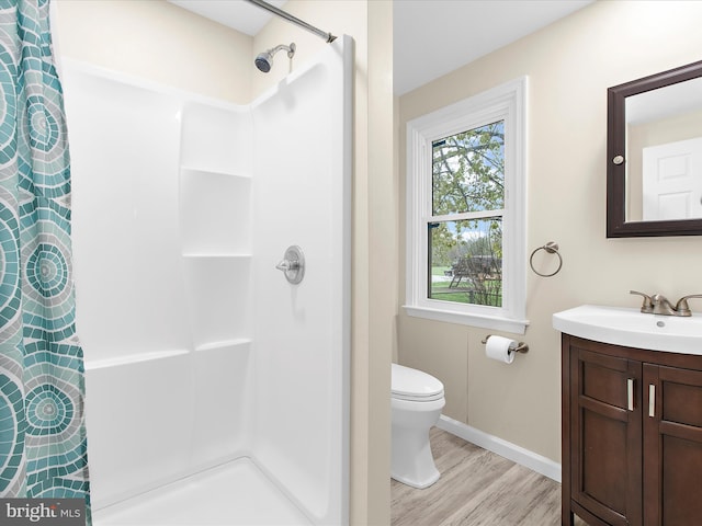 full bath with baseboards, curtained shower, toilet, vanity, and wood finished floors