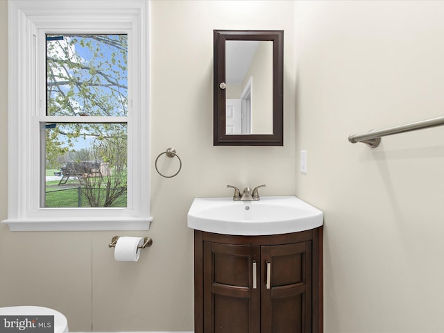 bathroom featuring vanity, toilet, and a healthy amount of sunlight