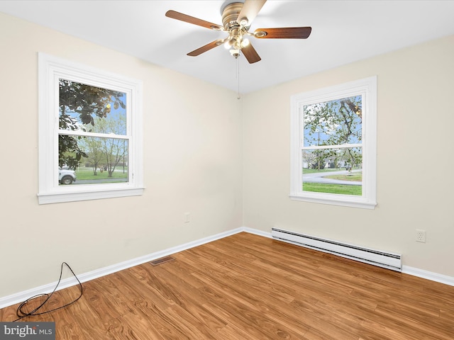 unfurnished room featuring a baseboard radiator, wood finished floors, ceiling fan, and baseboards