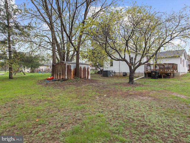 view of yard featuring a storage shed, a deck, an outdoor structure, and cooling unit