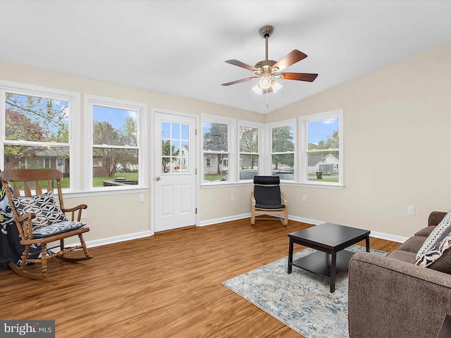 living room featuring wood finished floors, baseboards, and a ceiling fan