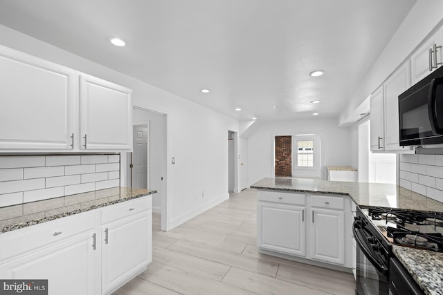 kitchen featuring backsplash, white cabinets, stone counters, and black appliances