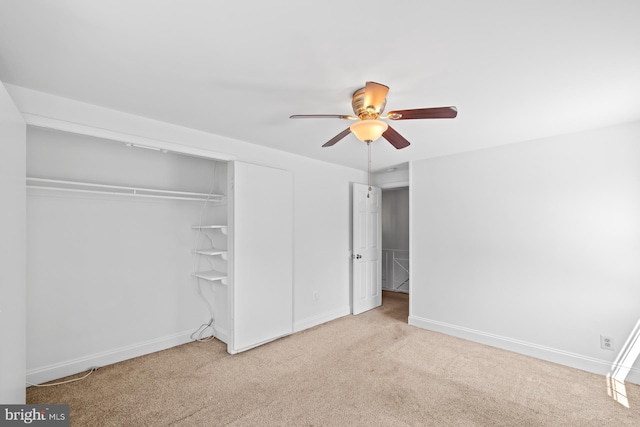 unfurnished bedroom featuring carpet floors, baseboards, ceiling fan, and a closet