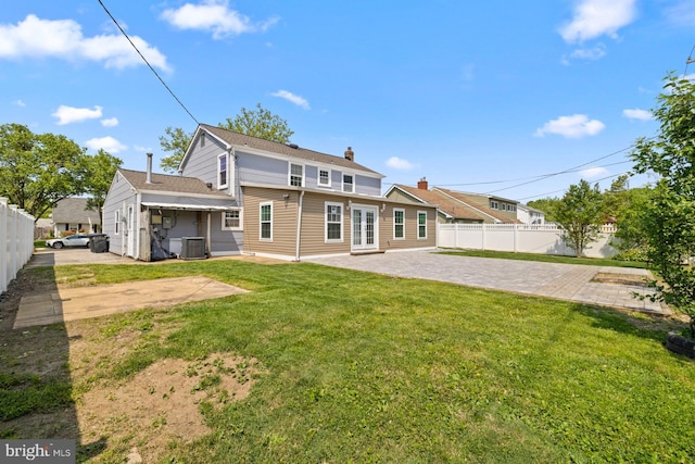 rear view of house with a patio, fence, a yard, and cooling unit