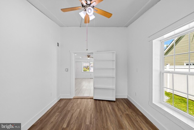 interior space featuring dark wood-type flooring, baseboards, and ceiling fan