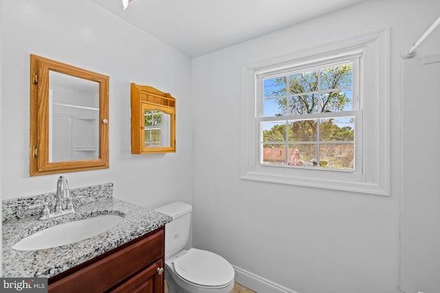 bathroom with toilet, baseboards, and vanity