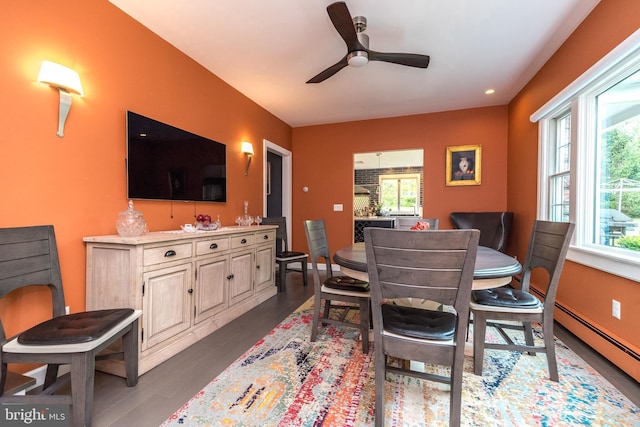 dining area featuring ceiling fan, a baseboard radiator, and dark wood-style flooring