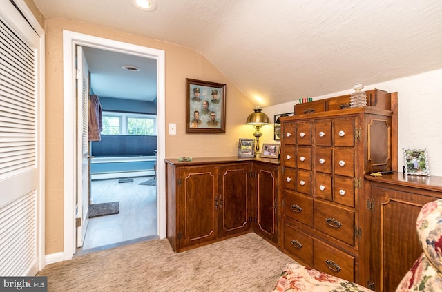hall with vaulted ceiling and light carpet