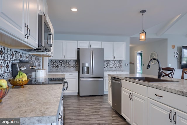 kitchen featuring a sink, white cabinetry, tasteful backsplash, appliances with stainless steel finishes, and hanging light fixtures