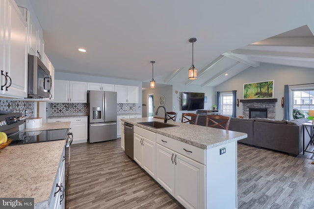 kitchen featuring light countertops, a sink, appliances with stainless steel finishes, white cabinets, and a healthy amount of sunlight