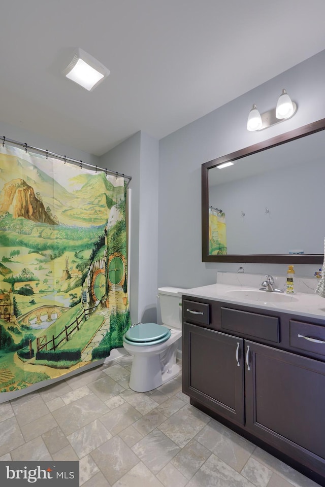 bathroom with toilet, vanity, and curtained shower