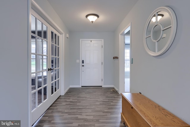 foyer entrance with baseboards, wood finished floors, and french doors