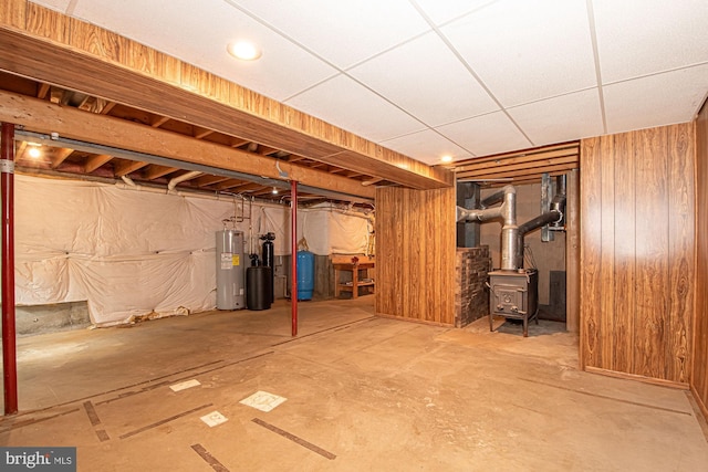302 Parkside Rd, Linden, VA 22642 - basement featuring water heater, a water pressure tank, a wood stove, and wood walls