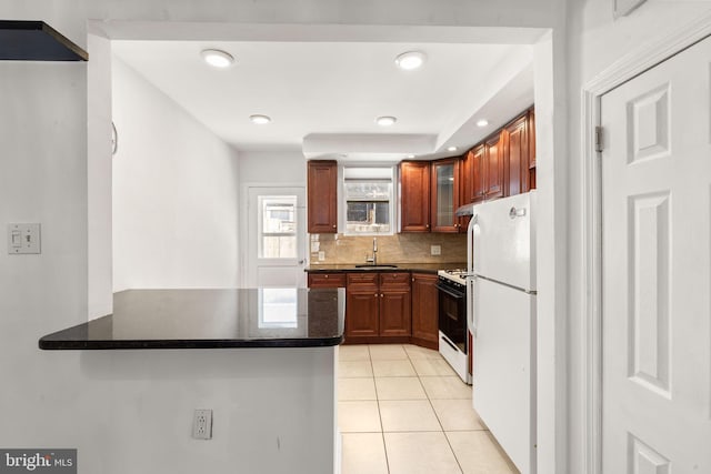 2225 S Hicks St, Philadelphia, PA 19145 - kitchen with gas stove, a sink, freestanding refrigerator, a peninsula, and light tile patterned floors