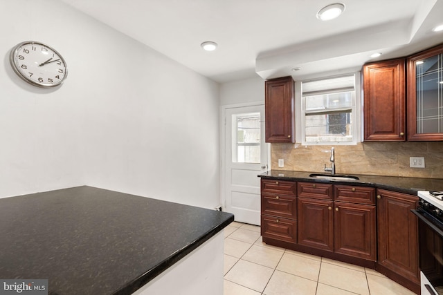 2225 S Hicks St, Philadelphia, PA 19145 - kitchen featuring light tile patterned flooring, a sink, tasteful backsplash, glass insert cabinets, and gas range