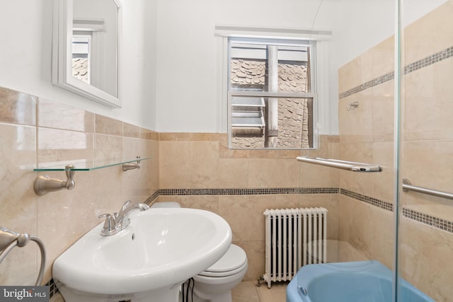 2225 S Hicks St, Philadelphia, PA 19145 - bathroom with tile walls, toilet, a shower with door, a sink, and radiator