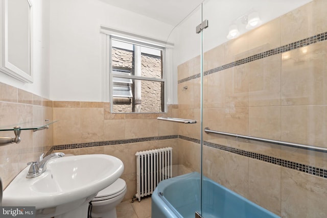 2225 S Hicks St, Philadelphia, PA 19145 - full bathroom featuring tile walls, toilet, radiator heating unit, tile patterned floors, and a sink