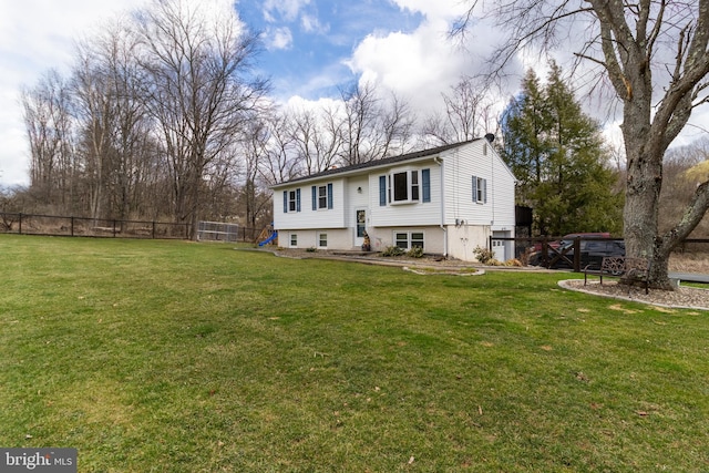 view of front of home with a front yard and fence