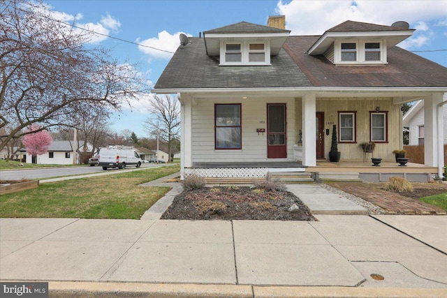 1402 Elm St, Lebanon, PA 17042 - bungalow-style home with a porch, a chimney, a shingled roof, and a front lawn