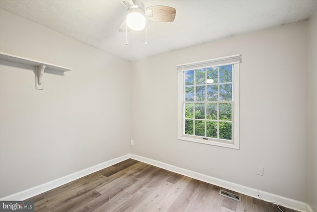 empty room with baseboards, wood finished floors, and ceiling fan