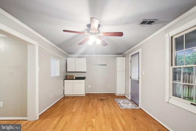 unfurnished living room with ceiling fan, light wood-style floors, crown molding, and baseboards