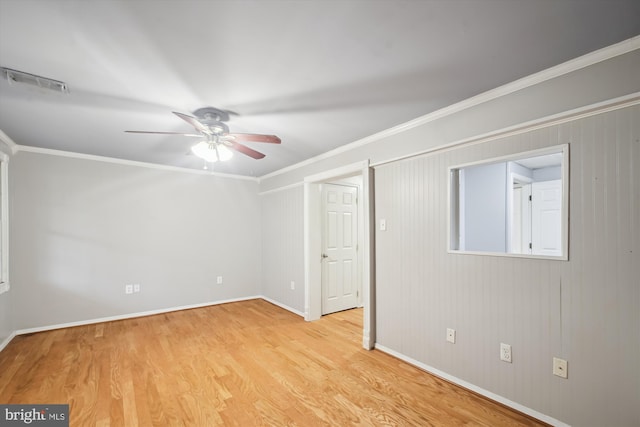 unfurnished room with ceiling fan, light wood-type flooring, baseboards, and crown molding