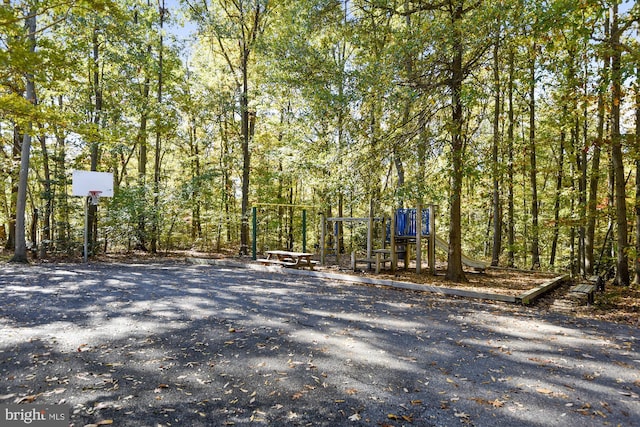 view of yard featuring a playground and a view of trees