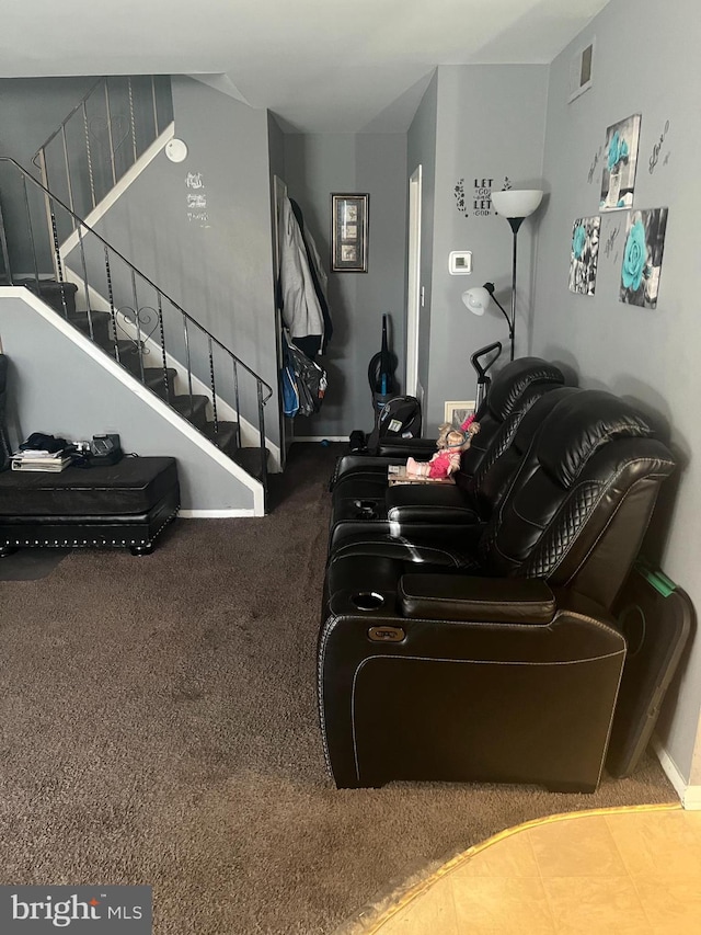 carpeted living area with baseboards, visible vents, and stairway