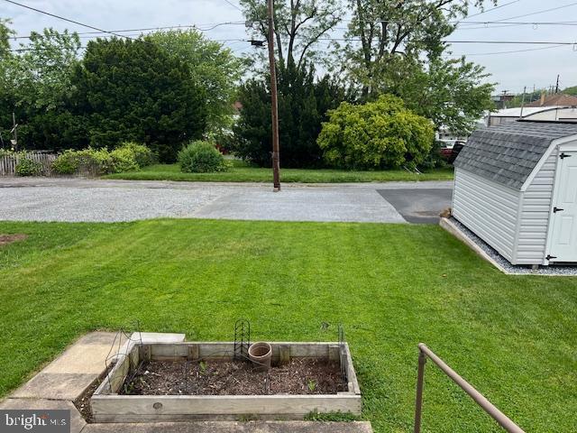 view of yard with a shed, an outbuilding, and a garden
