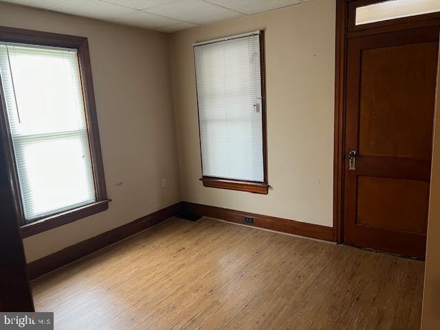 empty room with light wood-style flooring and baseboards