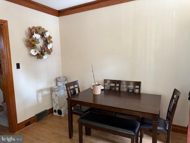 dining area featuring crown molding, visible vents, baseboards, and light wood-style floors