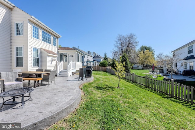 view of yard with a patio, outdoor dining space, a fenced backyard, and a residential view