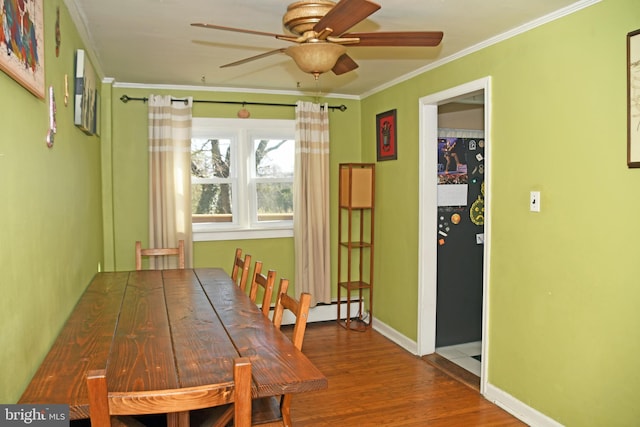 dining area featuring baseboard heating, baseboards, crown molding, ceiling fan, and wood finished floors