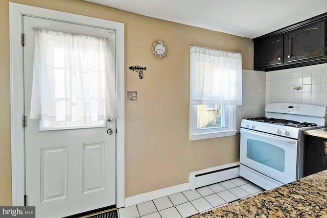 kitchen with a baseboard heating unit, white gas range oven, and a wealth of natural light