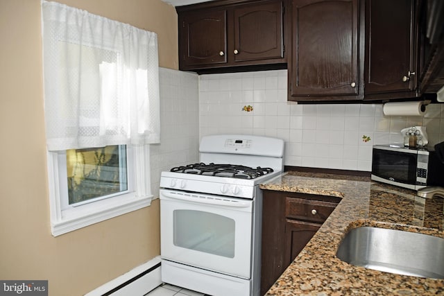 kitchen featuring a sink, dark brown cabinets, and white gas range