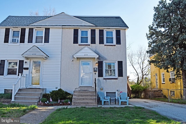 multi unit property with roof with shingles and stucco siding