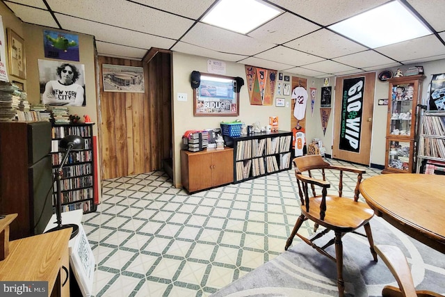 interior space with a paneled ceiling and light floors