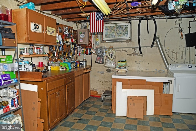 unfinished basement featuring washer / dryer and dark floors