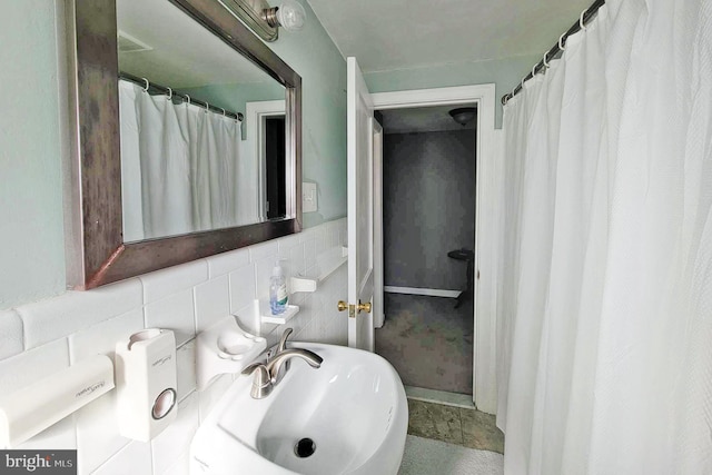 bathroom with a sink and tile walls