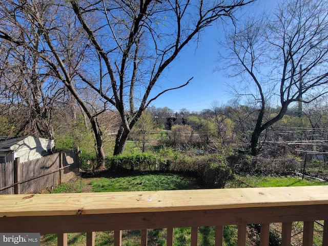 view of yard featuring a wooded view and fence