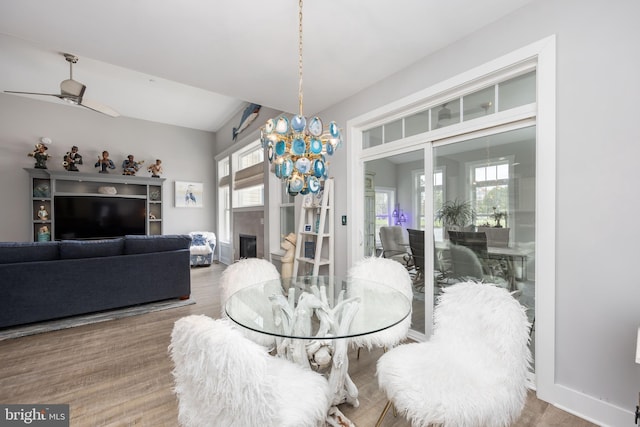13115 Muirfield Ln, Berlin, MD 21811 - dining space with ceiling fan with notable chandelier, baseboards, wood finished floors, and a fireplace