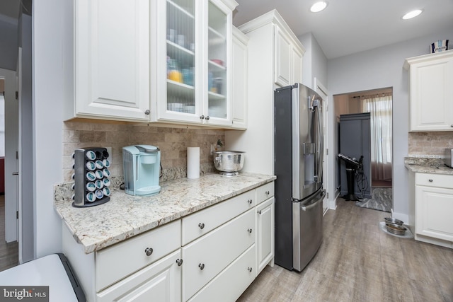 13115 Muirfield Ln, Berlin, MD 21811 - kitchen with tasteful backsplash, glass insert cabinets, white cabinets, stainless steel refrigerator with ice dispenser, and light wood finished floors