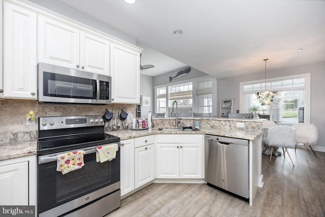 13115 Muirfield Ln, Berlin, MD 21811 - kitchen featuring a peninsula, appliances with stainless steel finishes, light wood finished floors, and a sink